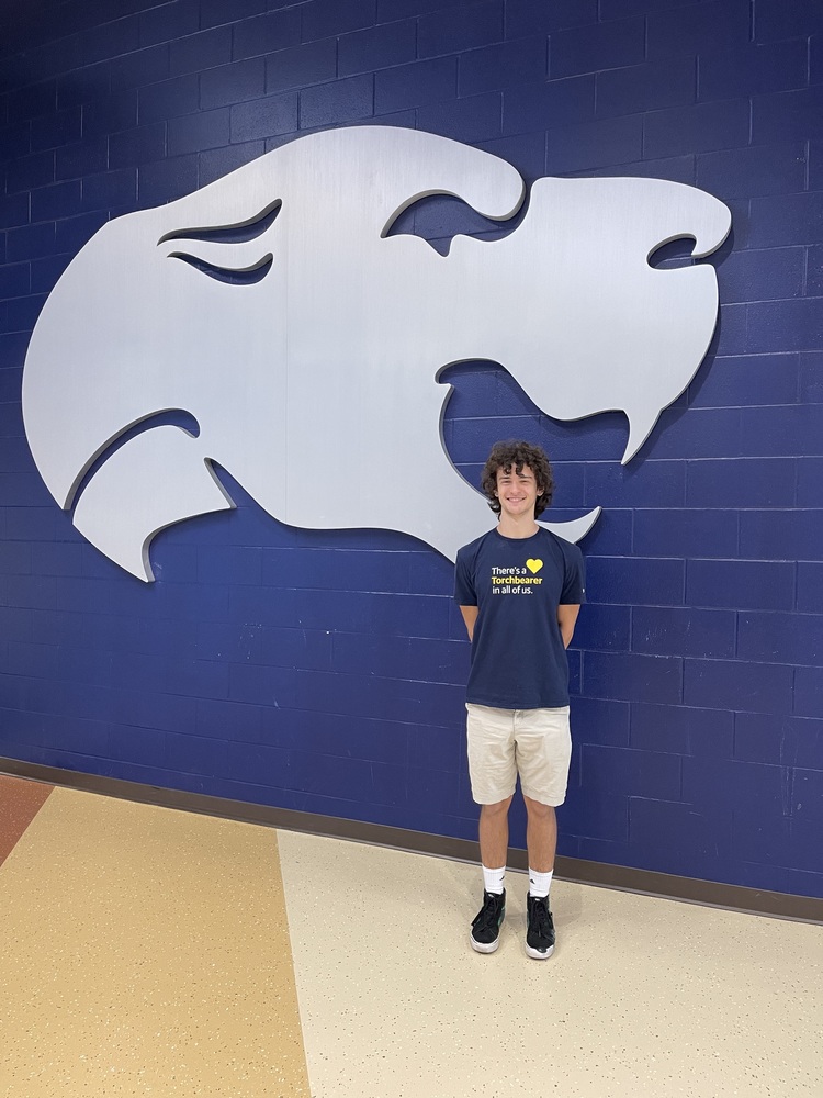 Caden standing in front of the Cougar at EHS 